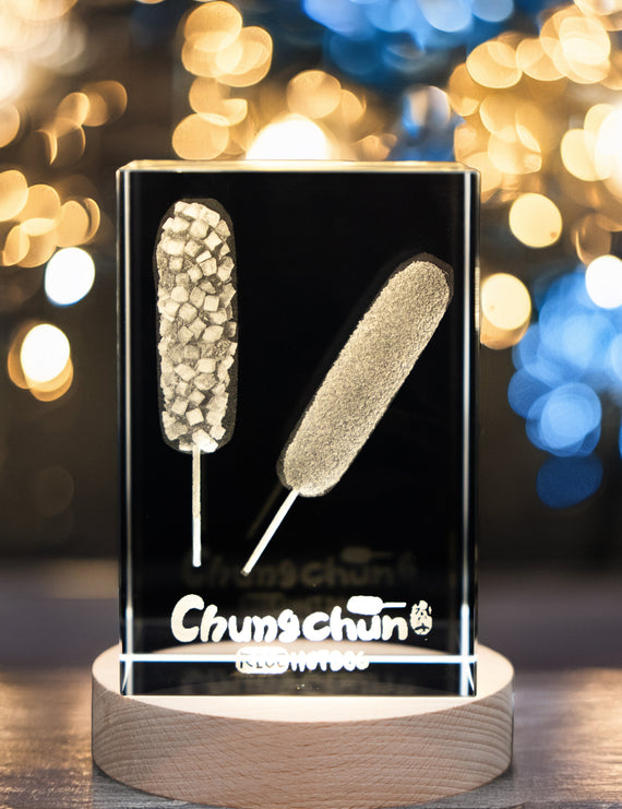 Glass display with corn dogs and 'Chum Chum' branding against a blurred lights background
